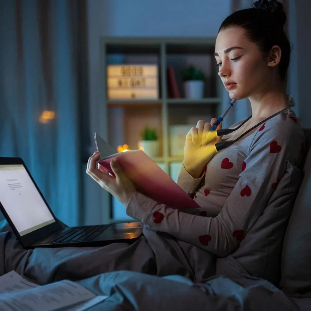Mujer leyendo de noche con la luz LED de cuello